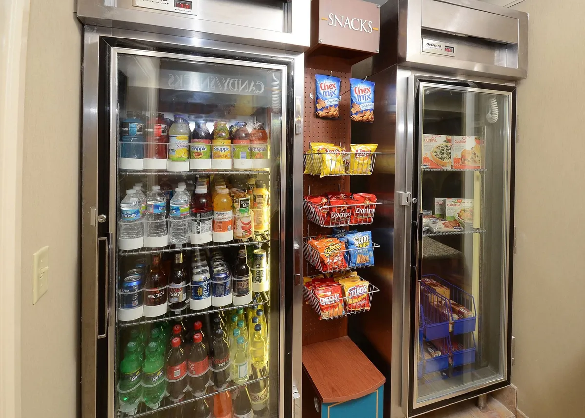This image displays a well-stocked refrigerated drink display and shelves brimming with snacks. The setting is casual and convenient, suggesting easy access for grabbing refreshments on the go. The array of options hints at hospitality and guest comfort, reflecting the hotel's focus on guest-centric amenities.